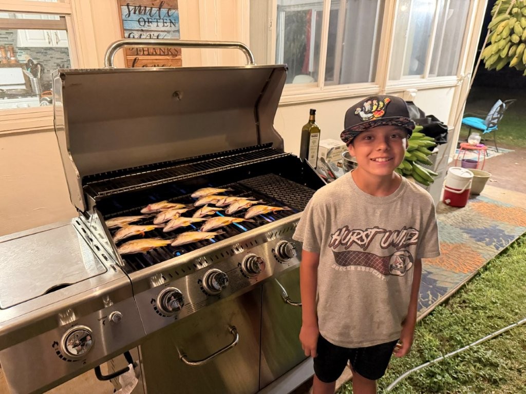 Noah by the grill with the snappers that he and Luke caught Noah by the grill with the snappers that he and Luke caught