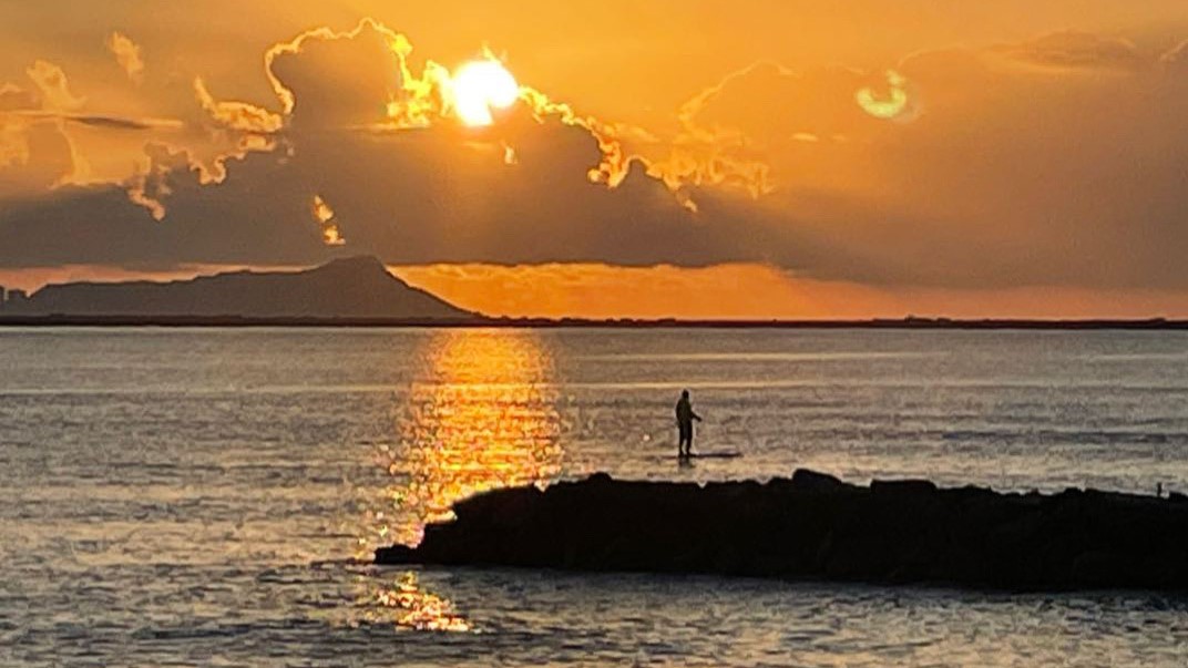 Willy on Paddleboard at Sunrise in front of house