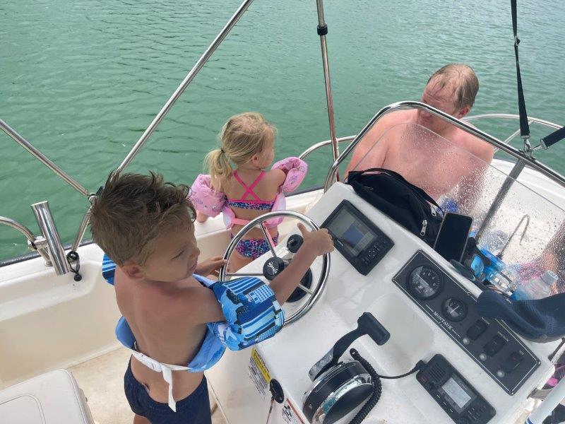 Hudson driving boat with Brookyn and Kirk